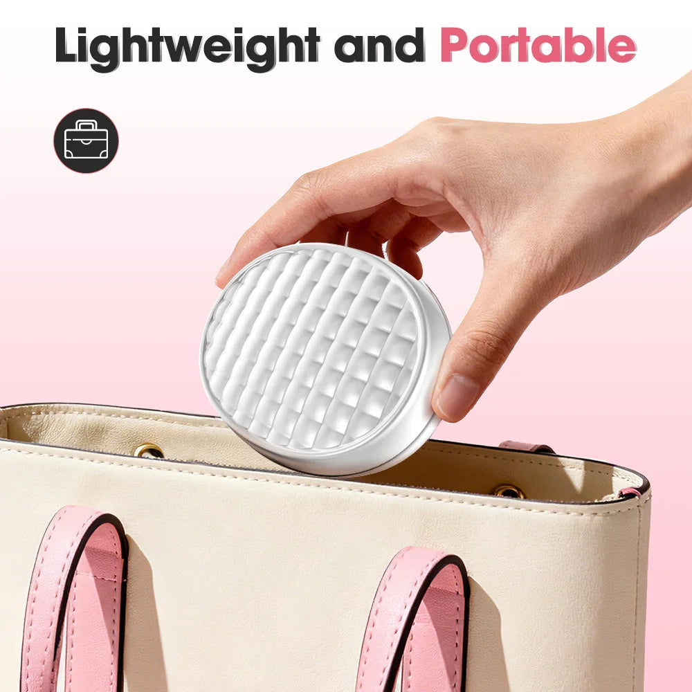 Hand placing portable light therapy device into beige handbag with pink straps